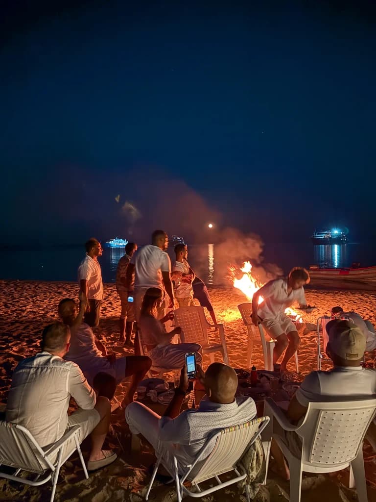 Feu de camp sur la plage la nuit avec membres